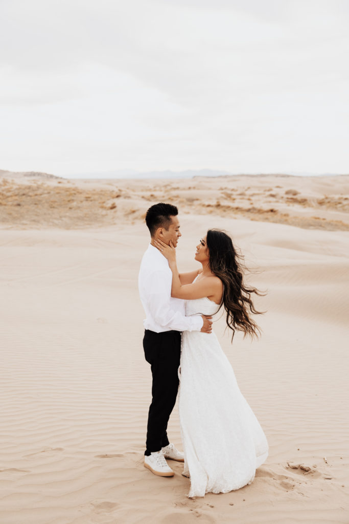 couple embrace in the sand dunes utah photography