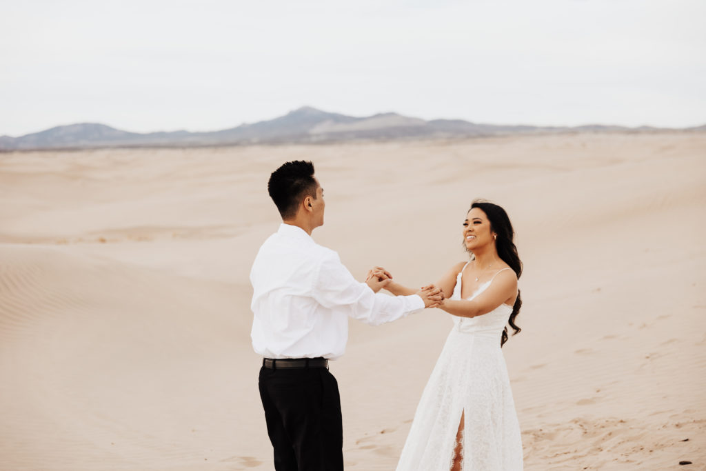 couple embrace in the sand dunes utah