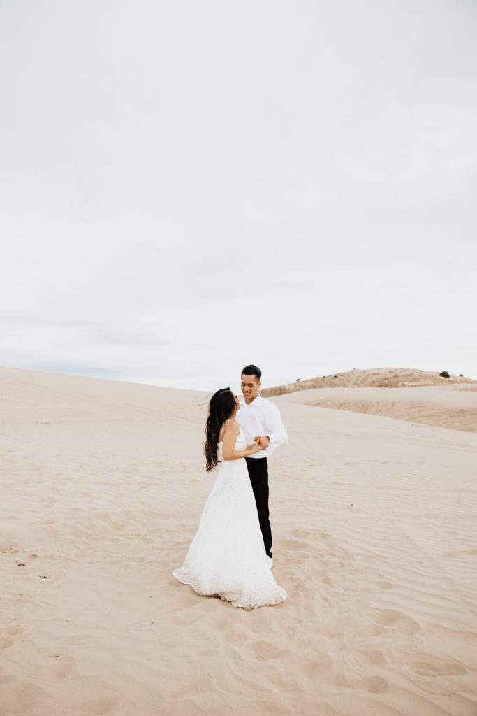couple embrace in the sand dunes utah photography