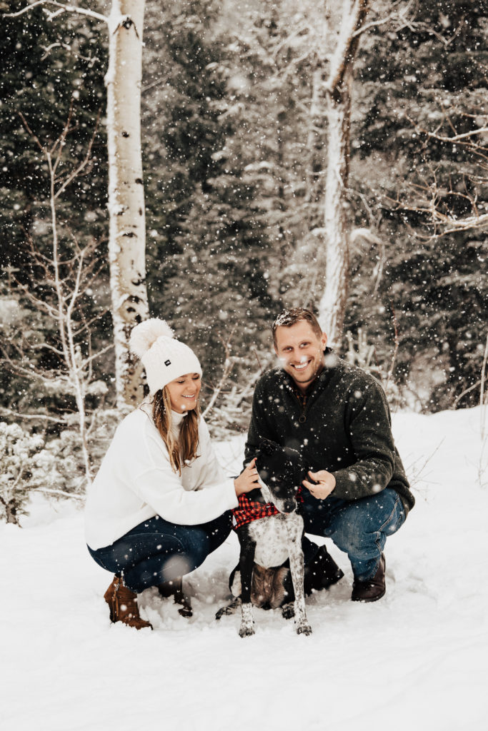 couple and dog engagement photos in the snow Utah