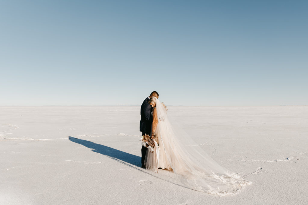 bride and groom embracing at the bonneville salt flats 

