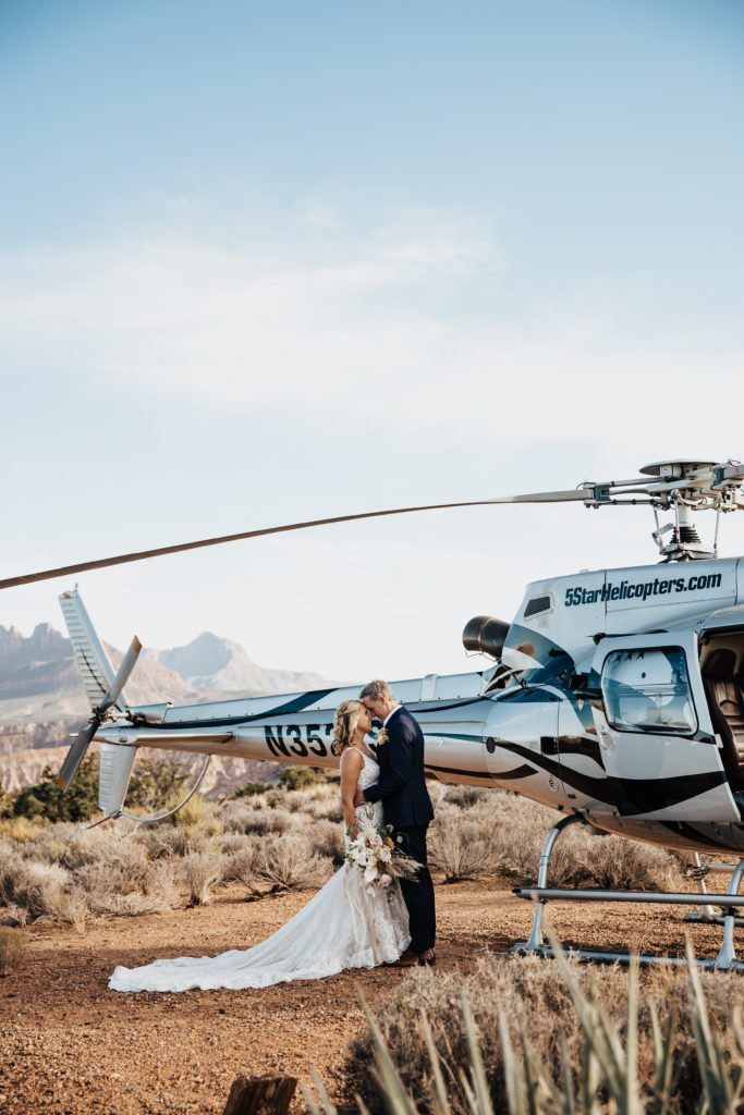 Bride & Groom kissing after a helicopter ride on their wedding day