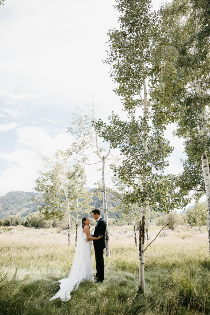 bride and groom standing by aspen trees in mountains of park city wedding venue